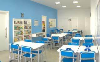 Sala de aula Kumon com cadeiras, mesas e, à esquerda, um expositor de livros com a parede toda azul