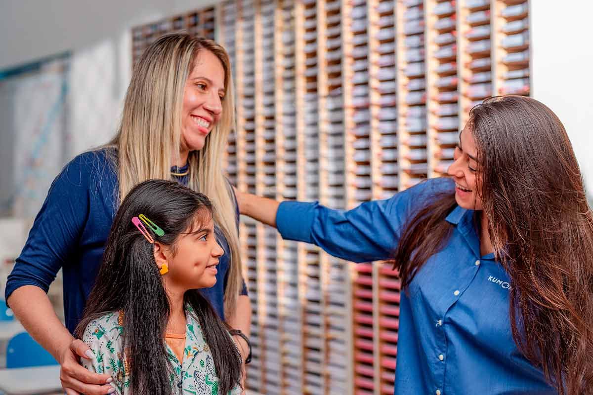 Mãe e filha sendo recebidas pela orientadora do método Kumon na unidade