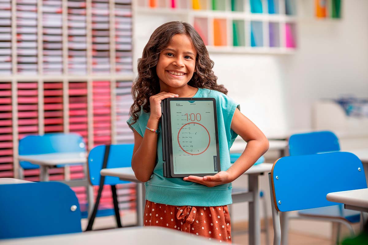 Aluna feliz mostrando a nota 100 no tablet